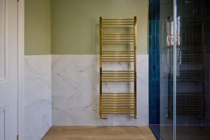 Blue Tiled Shower and Gold Towel Rail